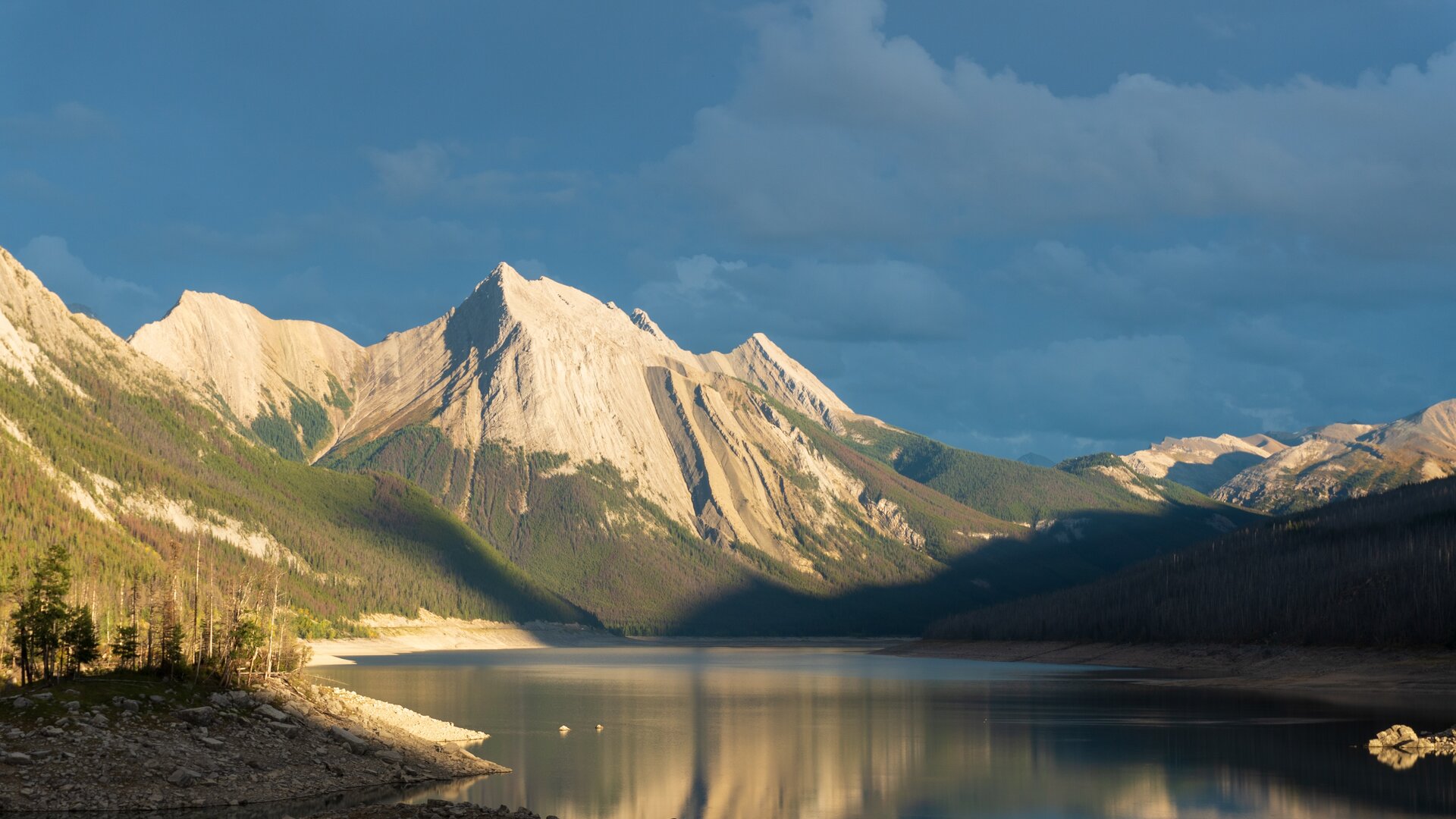 Late afternoon light on a mountain lake, the far shore already in shadow